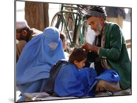 A Mother Watches as Her Child Gets a Haircut in the Center of Kabul, Afghanistan on Oct. 9, 2003.-null-Mounted Photographic Print