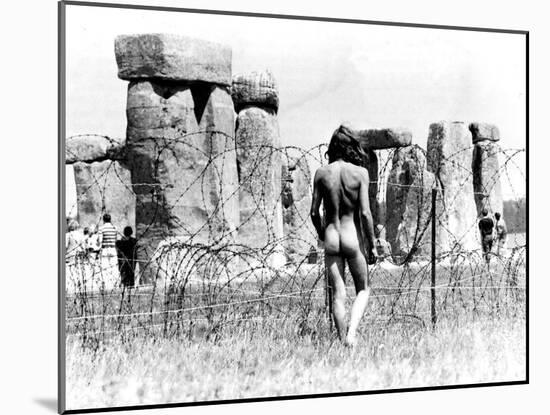 A Naked Hippy Watches Stonehenge from Behind Barb Wire on Summer Solstice-null-Mounted Premium Photographic Print