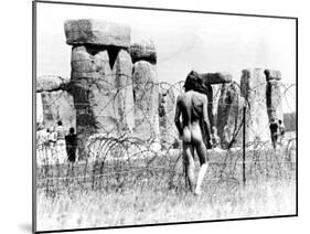 A Naked Hippy Watches Stonehenge from Behind Barb Wire on Summer Solstice-null-Mounted Premium Photographic Print