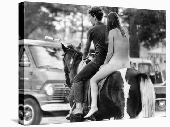 A Naked Young Women and Escort Ride a Horse Through Goose Lake Park at 3 Day Rock Music Festival-null-Stretched Canvas