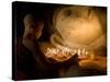 A Novice Monk Lighting Candles at a Massive Buddha Statue in Burma (Myanmar)-Kyle Hammons-Stretched Canvas