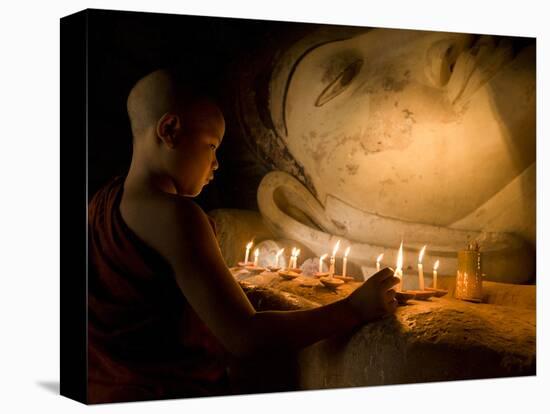 A Novice Monk Lighting Candles at a Massive Buddha Statue in Burma (Myanmar)-Kyle Hammons-Stretched Canvas