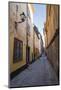 A pedestrian walks the streets of Stockholm's colorful and historic Gamla Stan district, Stockholm,-Jon Reaves-Mounted Photographic Print