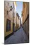 A pedestrian walks the streets of Stockholm's colorful and historic Gamla Stan district, Stockholm,-Jon Reaves-Mounted Photographic Print