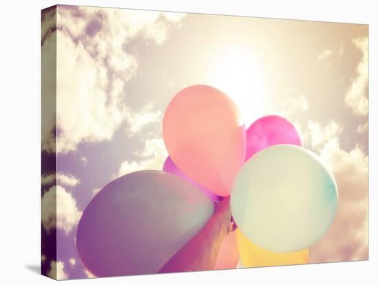 A Person Holding Multi Colored Balloons Done with a Retro Vintage Instagram Filter Effect-graphicphoto-Stretched Canvas