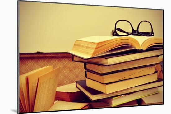 A Pile of Books and a Pair of Eyeglasses in an Old Suitcase, with a Retro Effect-nito-Mounted Photographic Print