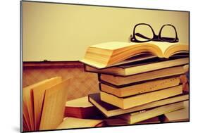 A Pile of Books and a Pair of Eyeglasses in an Old Suitcase, with a Retro Effect-nito-Mounted Photographic Print