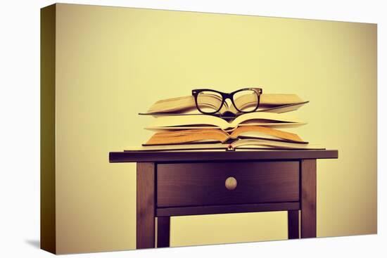 A Pile of Books and a Pair of Eyeglasses on a Desk, Symbolizing the Concept of Reading Habit or Stu-nito-Stretched Canvas
