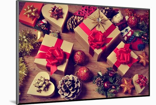 A Pile of Gifts and Christmas Ornaments, such as Christmas Balls, Stars and Tinsel, on a Rustic Woo-nito-Mounted Photographic Print