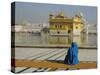 A Pilgrim in Blue Sits by the Holy Pool of Nectar at the Golden Temple, Punjab, India-Jeremy Bright-Stretched Canvas