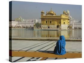 A Pilgrim in Blue Sits by the Holy Pool of Nectar at the Golden Temple, Punjab, India-Jeremy Bright-Stretched Canvas