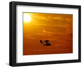 A Pilot Flies a Small Plane Past the Setting Sun Over Lake Winnipesaukee-null-Framed Photographic Print