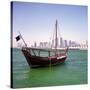 A Qatari Sailing Dhow, Called a Boom or Boum, with the National Flag Flying and the Doha Skyline-PaulCowan-Stretched Canvas