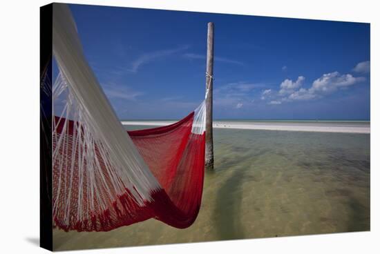 A Red Hammock Spread Out by the Wind Swings Above the Water During Low Tide, Hobox Island, Mexico-Karine Aigner-Stretched Canvas