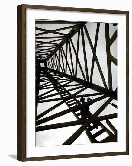 A Reenactor is Silhouetted Inside a Replica of the Spindletop Oil Derrick-null-Framed Photographic Print