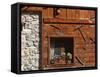 A Rich Wooden Wall with Rustic Tools and Window and a Stone Wall-null-Framed Stretched Canvas