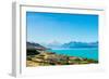 A road winds along the edge of a turquoise blue lake with mountains in the distance, New Zealand-Logan Brown-Framed Photographic Print