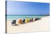 A Row of Colourful Wooden Deckchairs on Palm Beach, Aruba, Netherlands Antilles-Jane Sweeney-Stretched Canvas