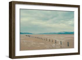 A Row of Wooden Posts on a Beach-Clive Nolan-Framed Photographic Print