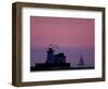 A Sailboat Slips Past a Lighthouse as the Sunset Comes to Lake Erie off the Coast of Cleveland-null-Framed Photographic Print