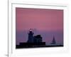 A Sailboat Slips Past a Lighthouse as the Sunset Comes to Lake Erie off the Coast of Cleveland-null-Framed Photographic Print