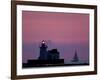 A Sailboat Slips Past a Lighthouse as the Sunset Comes to Lake Erie off the Coast of Cleveland-null-Framed Photographic Print