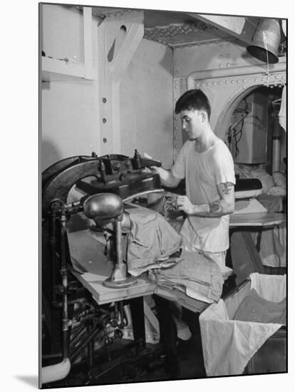 A Sailor Pressing Uniform Trousers in the Tailor Shop of a US Navy Cruiser-null-Mounted Photographic Print