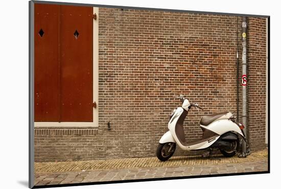 A Scooter Parked on the Sidewalk Outside of Oude Kerk Church in Amsterdam, Netherlands-Carlo Acenas-Mounted Photographic Print