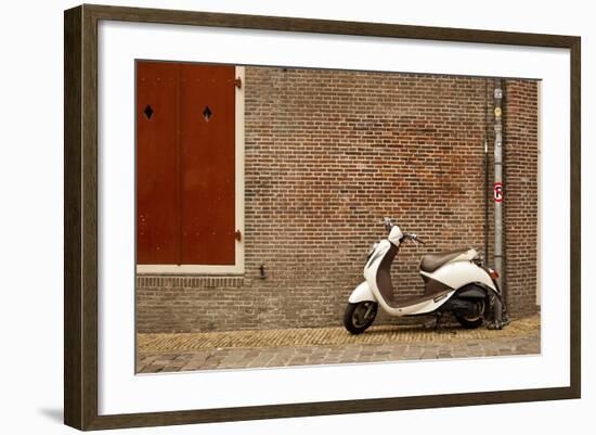 A Scooter Parked on the Sidewalk Outside of Oude Kerk Church in Amsterdam, Netherlands-Carlo Acenas-Framed Photographic Print