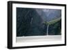 A sightseeing ship dwarfed by a tall waterfall in a fjord, South Island, New Zealand, Pacific-Logan Brown-Framed Photographic Print