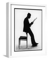 A Silhouette of a Businessman Leaning Against a Chair Reading a Newspaper-null-Framed Photographic Print