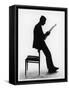 A Silhouette of a Businessman Leaning Against a Chair Reading a Newspaper-null-Framed Stretched Canvas