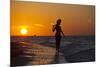 A Silhouette of a Woman Wearing a Hat Walking in the Surf at Sunset on Holbox Island, Mexico-Karine Aigner-Mounted Photographic Print