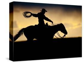 A Silhouetted Cowboy Riding Alone a Ridge at Sunset in Shell, Wyoming, USA-Joe Restuccia III-Stretched Canvas