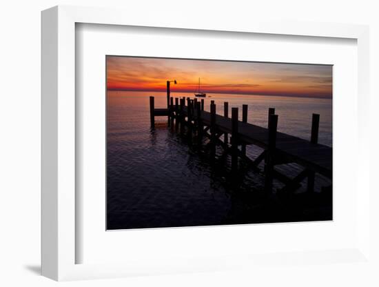 A Single Sailboat Sits on the Water of the Bay Alongside an Empty Dock on Tilghman Island, Maryland-Karine Aigner-Framed Photographic Print