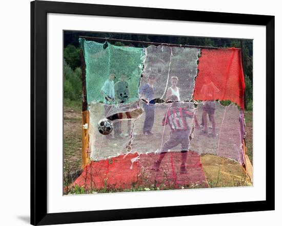 A Soccer Ball Slips Through an Opening of a Makeshift Goal-null-Framed Photographic Print