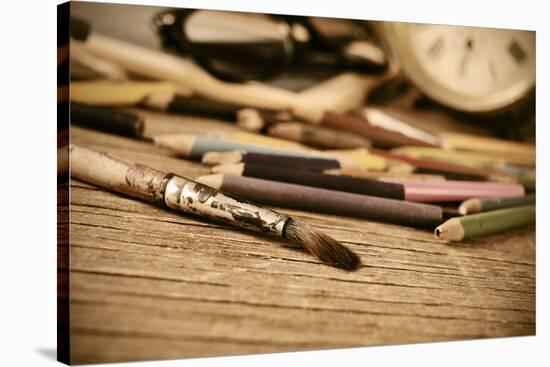 A Stained Brush, Colored Pencils of Different Colors, a Pair of Eyeglasses and an Old Clock on a Ta-nito-Stretched Canvas