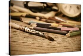 A Stained Brush, Colored Pencils of Different Colors, a Pair of Eyeglasses and an Old Clock on a Ta-nito-Stretched Canvas