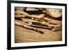 A Stained Brush, Colored Pencils of Different Colors, a Pair of Eyeglasses and an Old Clock on a Ta-nito-Framed Premium Photographic Print