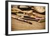 A Stained Brush, Colored Pencils of Different Colors, a Pair of Eyeglasses and an Old Clock on a Ta-nito-Framed Photographic Print