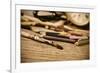 A Stained Brush, Colored Pencils of Different Colors, a Pair of Eyeglasses and an Old Clock on a Ta-nito-Framed Photographic Print