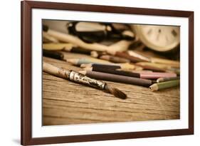 A Stained Brush, Colored Pencils of Different Colors, a Pair of Eyeglasses and an Old Clock on a Ta-nito-Framed Photographic Print