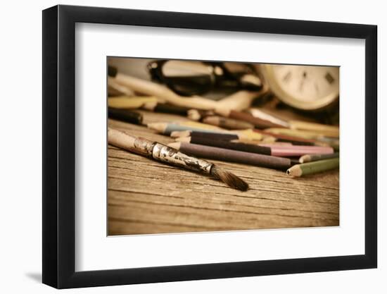 A Stained Brush, Colored Pencils of Different Colors, a Pair of Eyeglasses and an Old Clock on a Ta-nito-Framed Photographic Print