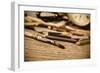 A Stained Brush, Colored Pencils of Different Colors, a Pair of Eyeglasses and an Old Clock on a Ta-nito-Framed Photographic Print