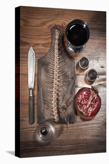 A Still Life Featuring a Fish Skeleton, Pomegranate and Red Wine-Komar-Stretched Canvas