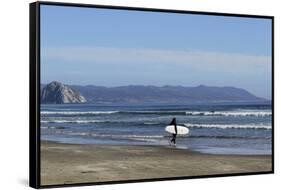 A surfer approaches the water, Morro Rock in the background. San Luis Obispo County, California, Us-Susan Pease-Framed Stretched Canvas