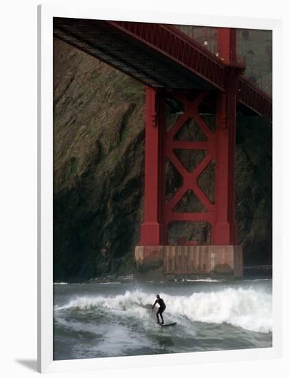 A Surfer is Dwarfed by the Northern End of the Golden Gate Bridge While Riding the Waves-null-Framed Photographic Print