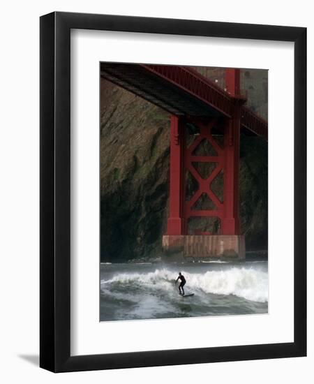 A Surfer is Dwarfed by the Northern End of the Golden Gate Bridge While Riding the Waves-null-Framed Photographic Print