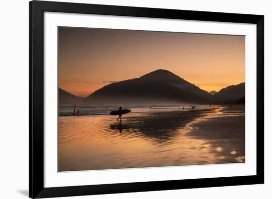 A Surfer Makes His Way Out of the Water at Sunset on Praia Do Itamambuca in Brazil-Alex Saberi-Framed Photographic Print