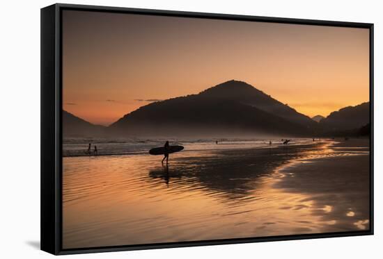 A Surfer Makes His Way Out of the Water at Sunset on Praia Do Itamambuca in Brazil-Alex Saberi-Framed Stretched Canvas